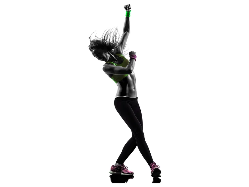 Silhouette d'une femme qui danse, bras levé, en pleine chorégraphie.