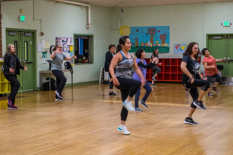 Cours de Zumba en soirée dans une salle communautaire.